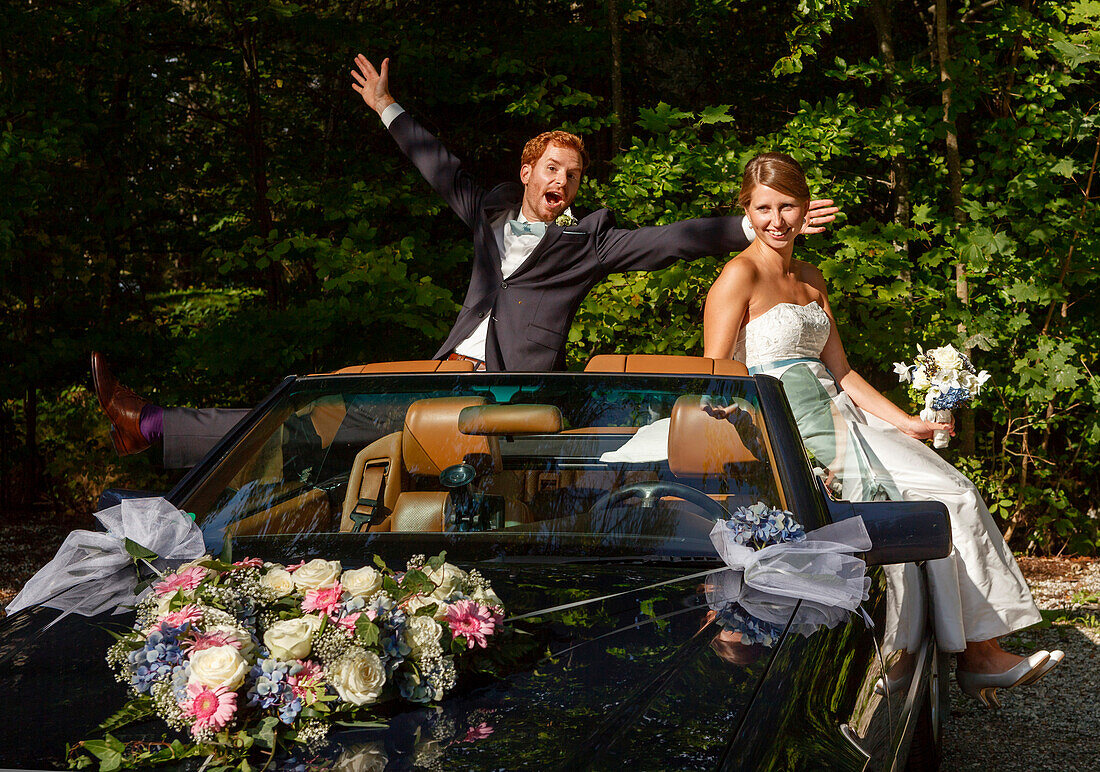 Brautpaar jubelt im Auto, Bayern, Deutschland