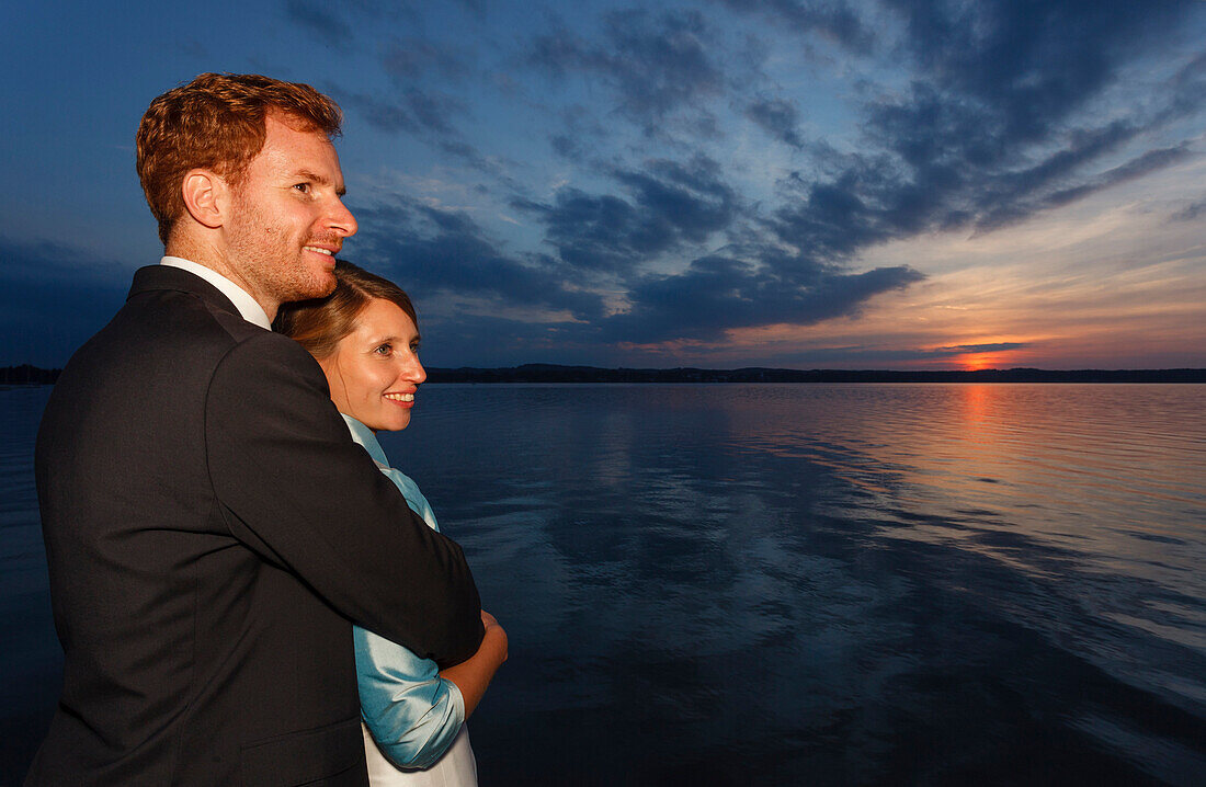 Brautpaar schaut in den Sonnenuntergang, Starnberger See, Bayern, Deutschland