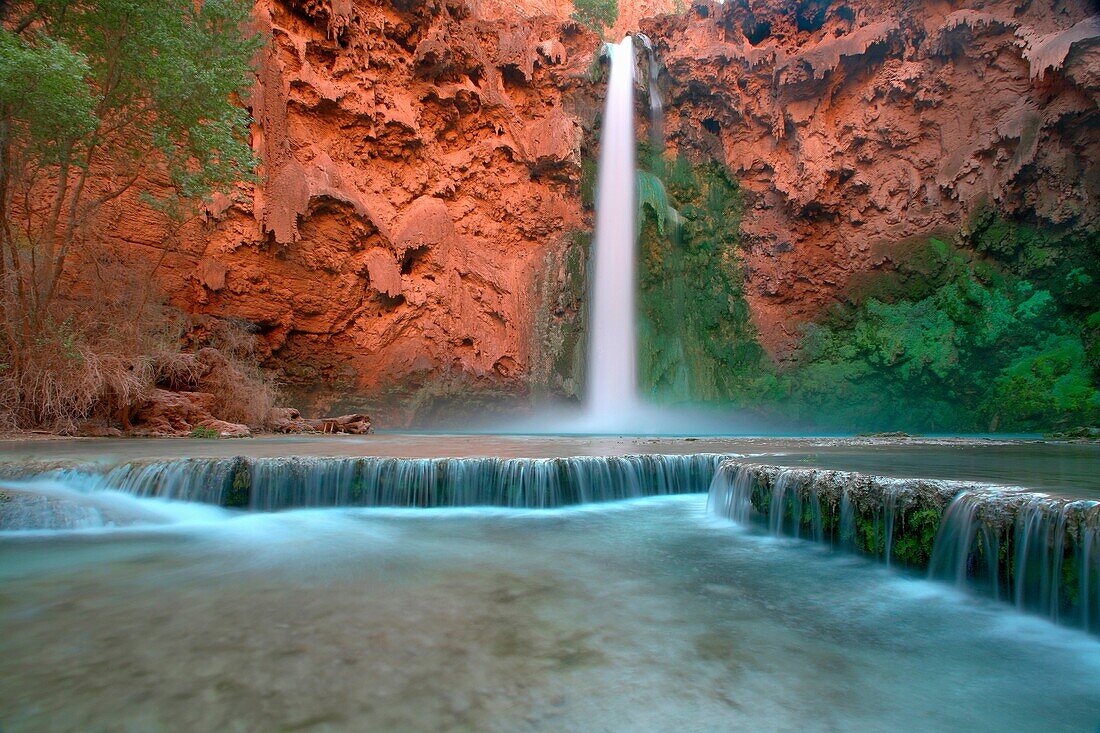 Low angle view in the Grand Canyon as Mooney Falls drop into turquoise pool, USA, Arizonal