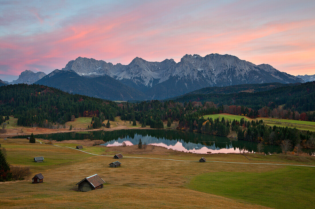 Almwiese mit Heustadeln, Blick über den Geroldsee auf das Karwendelgebirge, bei Mittenwald, Bayern, Deutschland