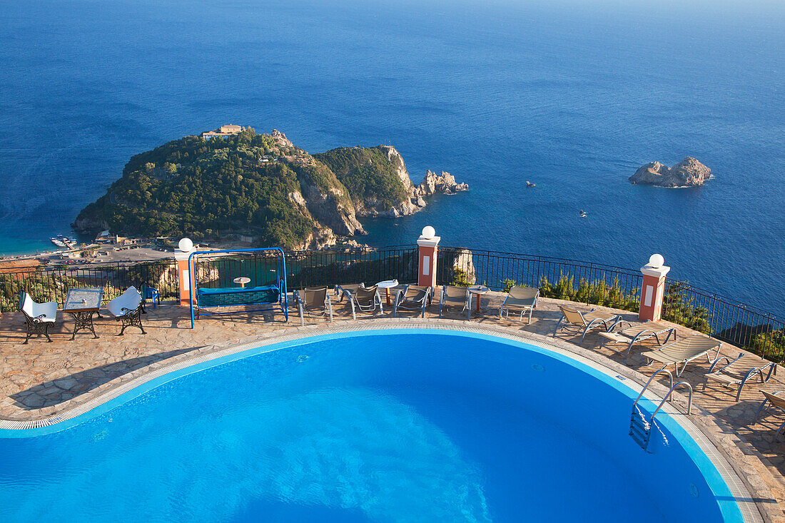 View from the pool of the Golden Fox Hotel over Paleokastritsa Bay to Panagia Theotokou monastery, Corfu island, Ionian islands, Greece
