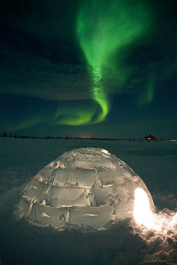 Aurora borealis over igloo, Hudson Bay, northern Manitoba, Canada