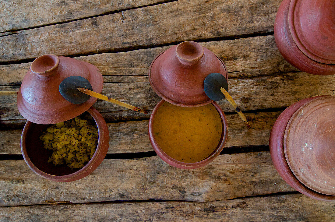 Sri Lanka Currys in Tongeschirr auf alten Holzstämmen, Resort, Westküste nördlich von Colombo, Sri Lanka