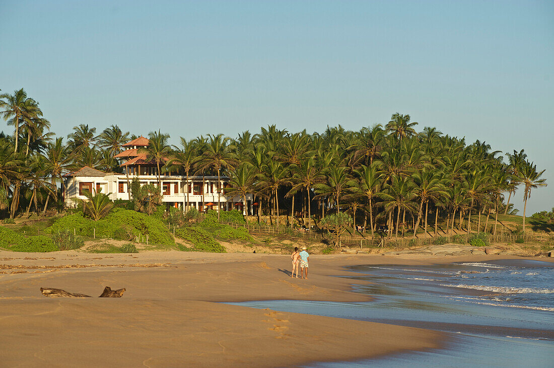 Two tourists on a deserted beach, Turtle Bay Hotel in the background, Tangalle, South Sri Lanka