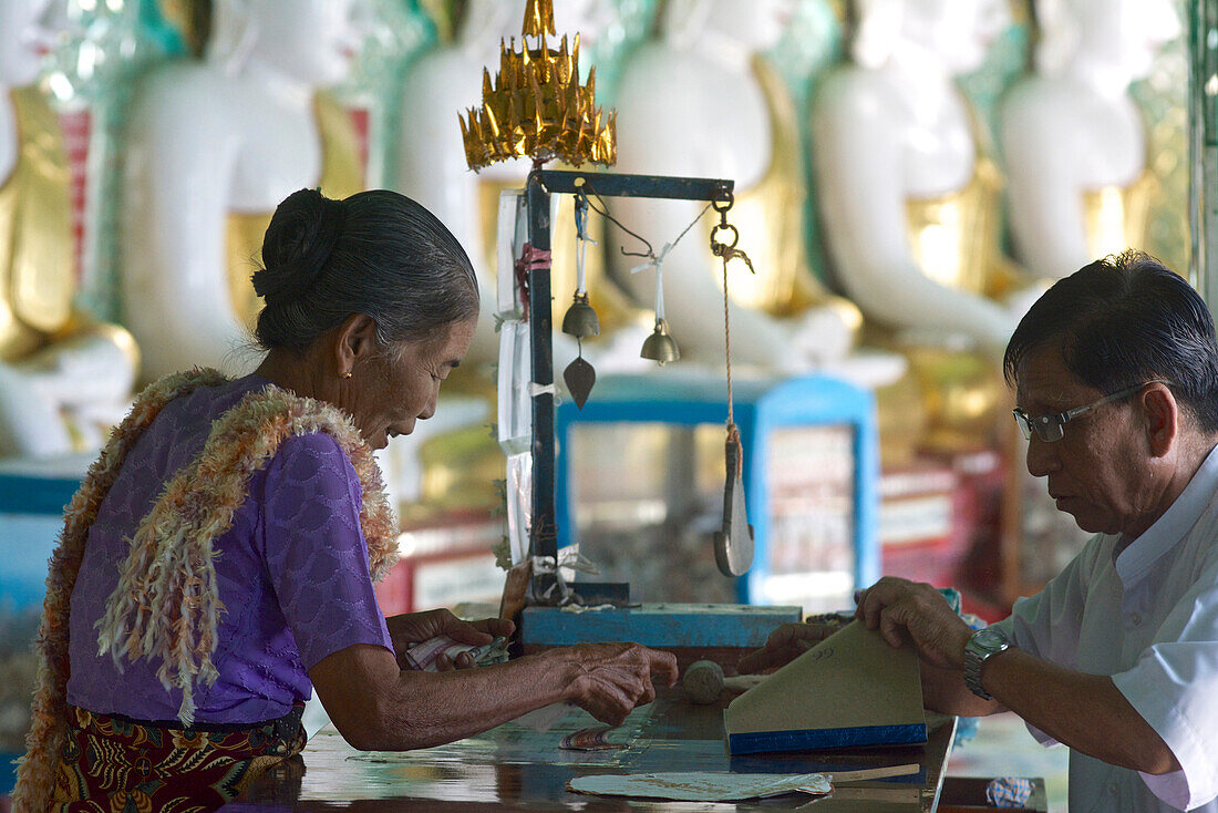 Gold leaf salesperson in Oohmin Thonze pagoda, Sagaing Hill on the banks of Irrawaddy river, 20km from Mandalay, Myanmar, Burma