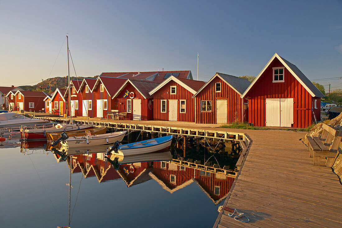 Boats and boot houses in Bleket port with reflection in the water, Tjoern Island, Province of Bohuslaen, West coast, Sweden, Europe