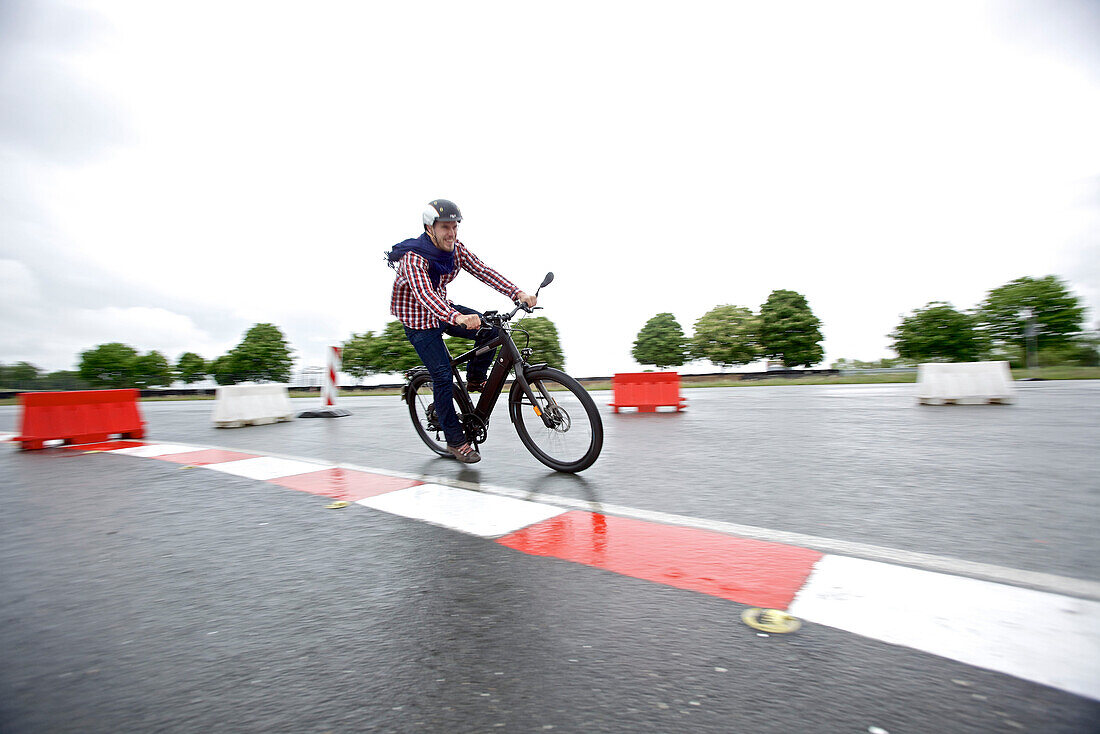 Man riding an electric bicycle on a test track, Tanna, Thuringia, Germany