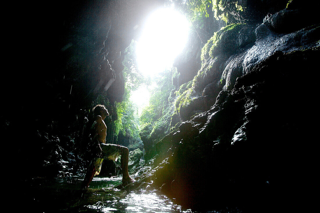 Man at a little waterfall, Denpasar, Bali, Indonesia