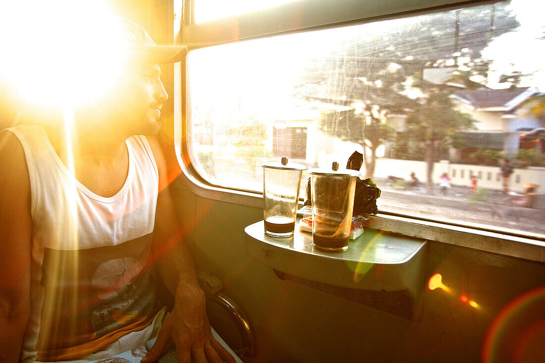 Mann sieht aus einem Zugfenster, Jakarta, Java, Indonesien