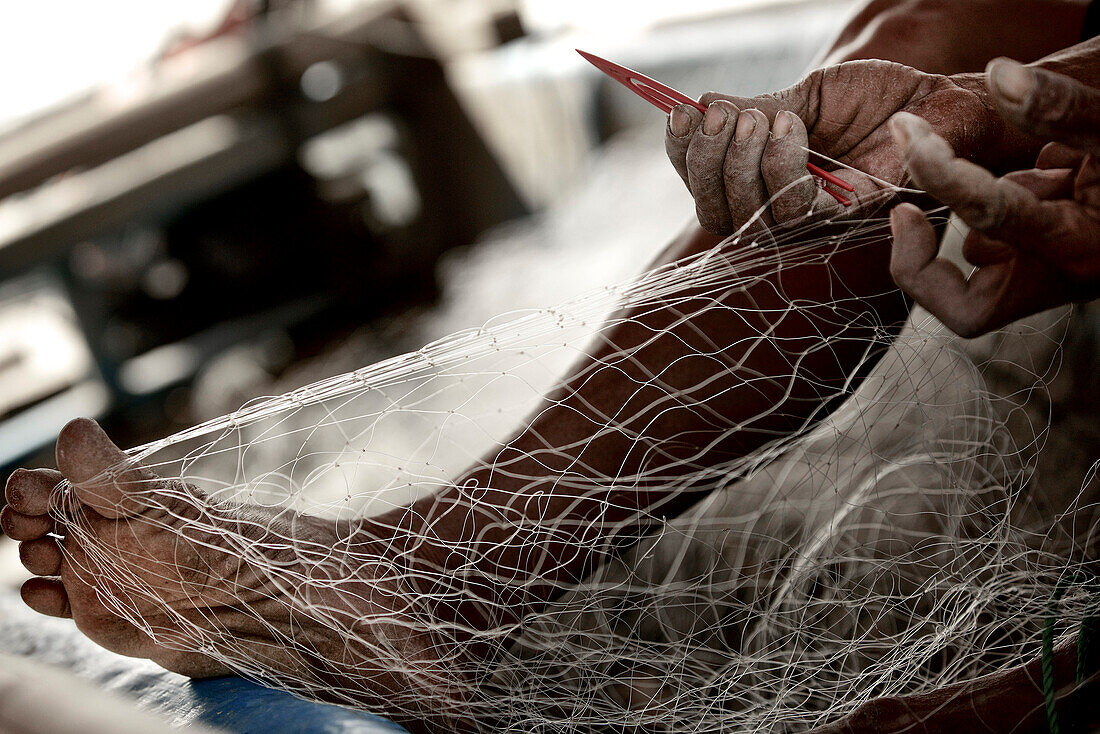 Fisherman reparing fishnet, Mataram, Lombok, Indonesia