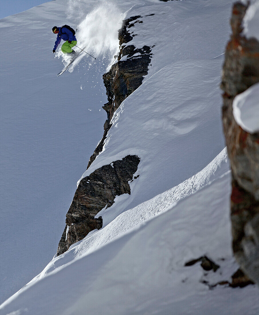 Freeskier springt über eine Felsklippe, Chandolin, Kanton Wallis, Schweiz