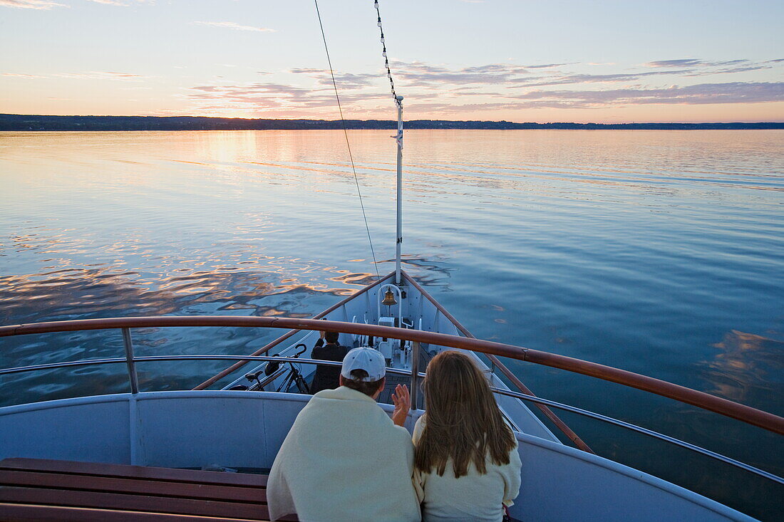 Couple sitting on deck of a ship, Ammersee, Upper Bavaria, Bavaria, Germany