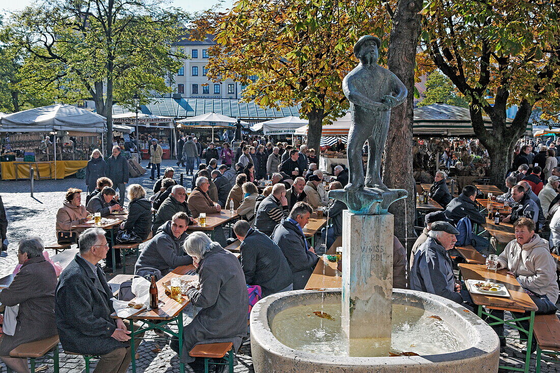 Biergarten am Viktualienmarkt mit dem Weiß Ferdl Brunnen, München, Oberbayern, Bayern, Deutschland