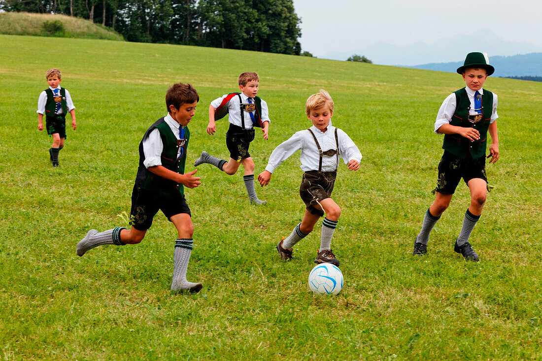 Kinder in Tracht spielen Fussball, Jasberg, Dietramszell, Oberbayern, Bayern, Deutschland