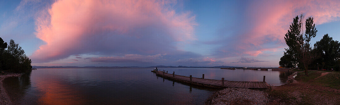 Jetty at the lake shore, clouds at sunset, Castiglione del Lago, Lago Trasimeno, province of Perugia, Umbria, Italy, Europe