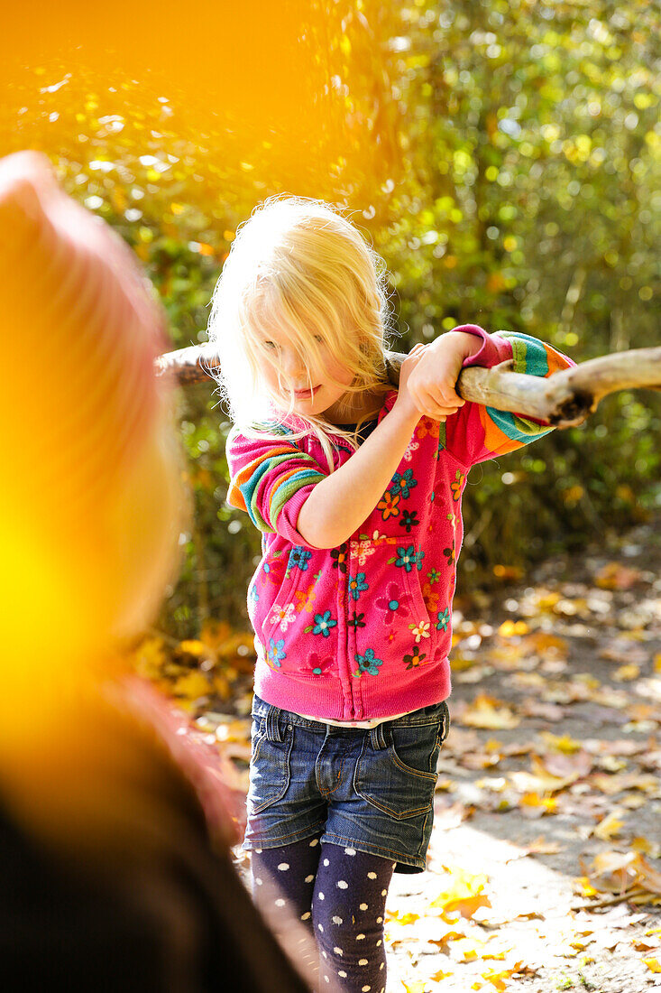 Girl (4 years) playing in an autumn forest, Goseck, Saxony-Anhalt, Germany