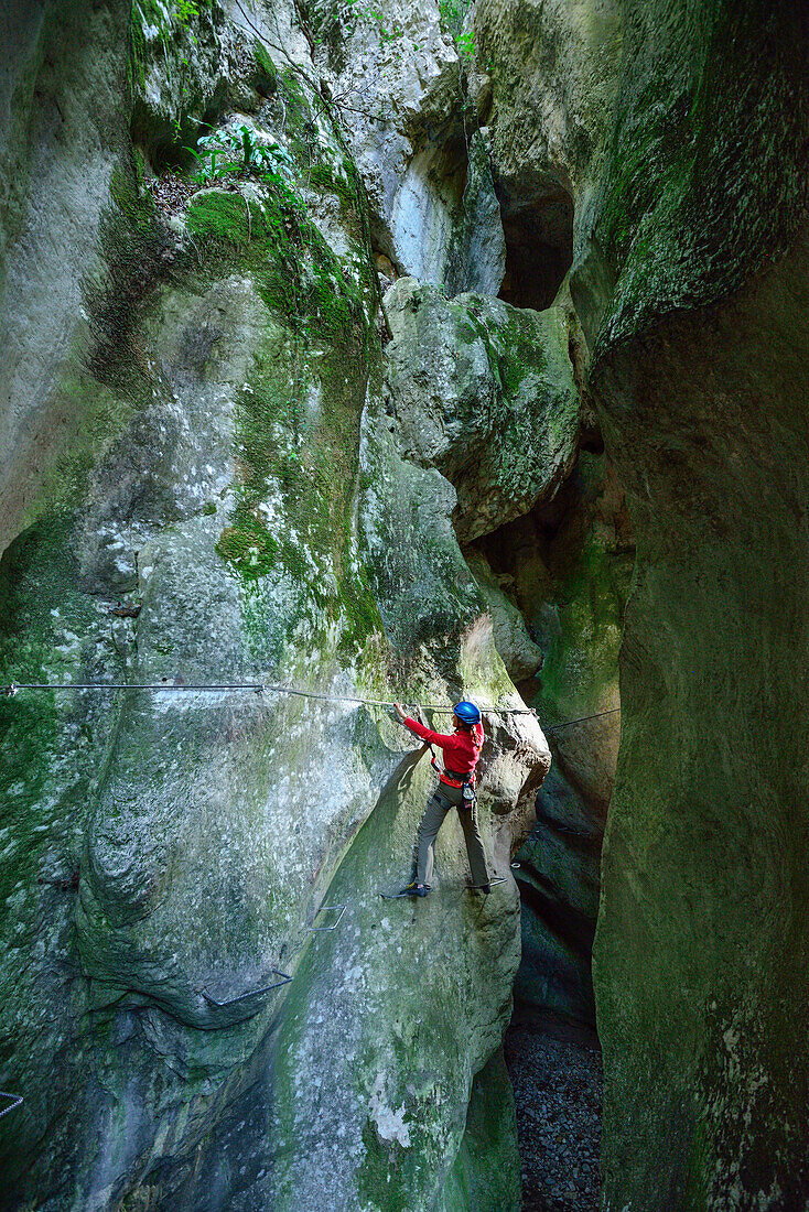 Frau steigt auf Klettersteig Sentiero Rio Sallagoni durch Sallagoni-Schlucht, Sentiero Rio Sallagoni, Gardaseeberge, Trentino, Italien