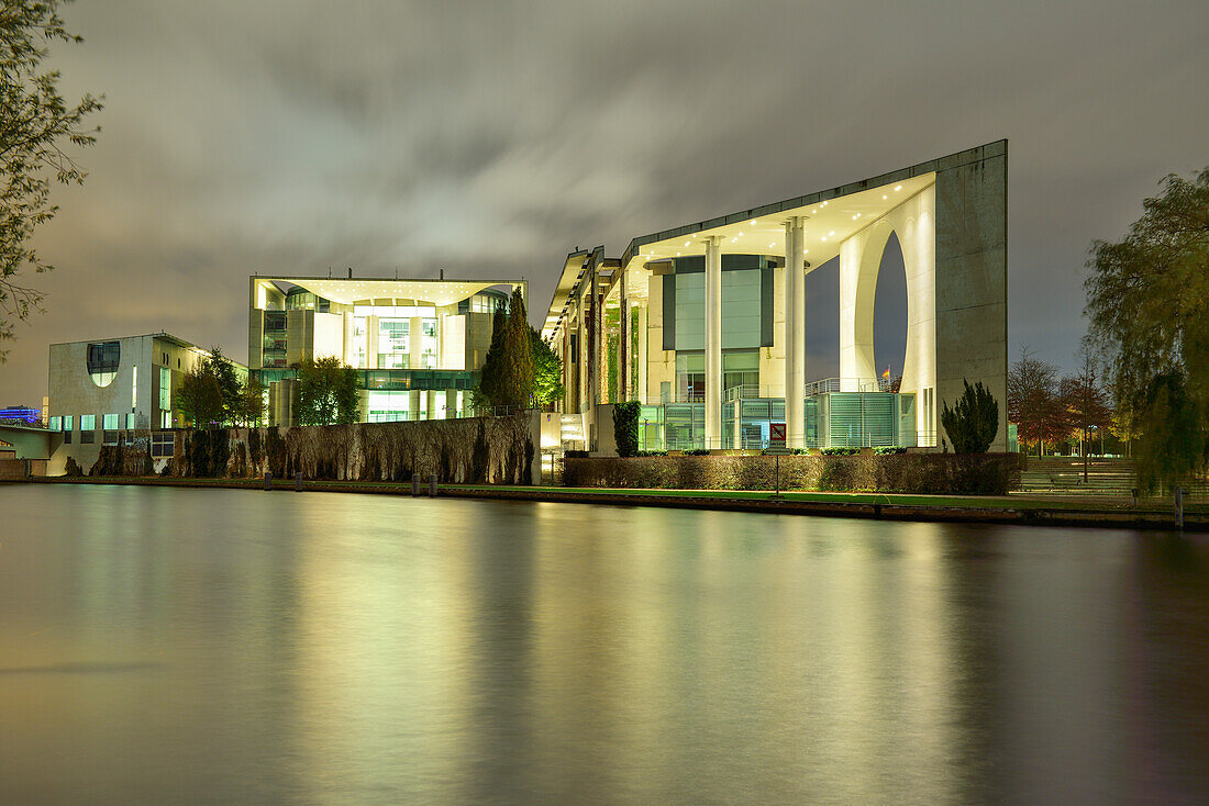 Illuminated building of the Bundeskanzleramt reflecting in the river Spree, architects Axel Schultes and Charlotte Frank, Berlin, Germany