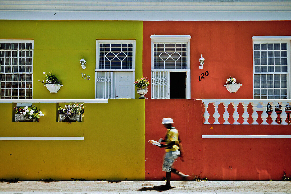 Mann läuft vor farbigen Häusern im Bo Kaap Viertel, Kapstadt, Südafrika, Afrika