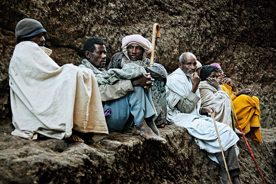 Eine Gruppe von Pilgern sitzen auf einem Felsvorsprung, Lalibela, Äthiopien, Afrika