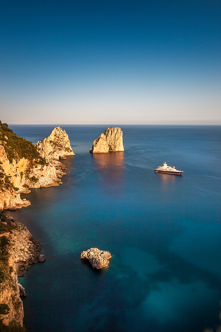 Yacht in front of the Faraglioni stacks, Capri, Bay of Naples, Campania, Italy