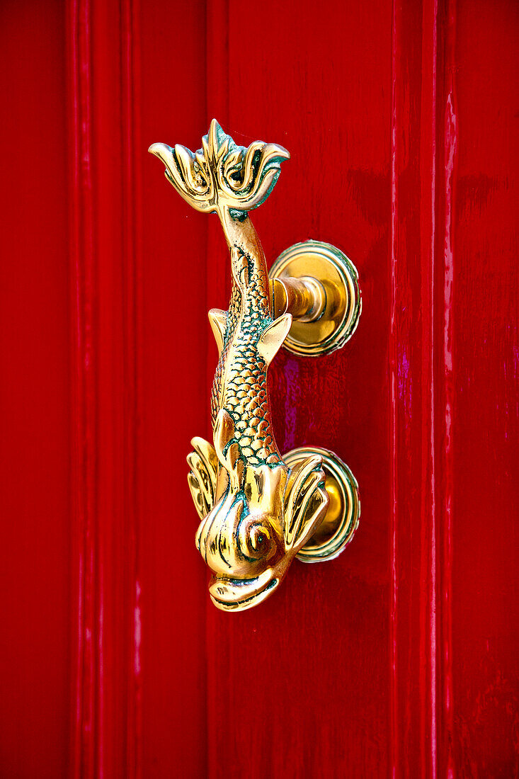 Golden door handle on a red door, Mdina, Malta