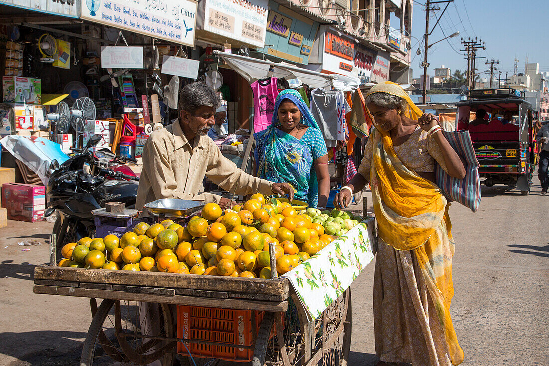 Two women at a fruit stand in the city center, Porbandar, Gujarat, India