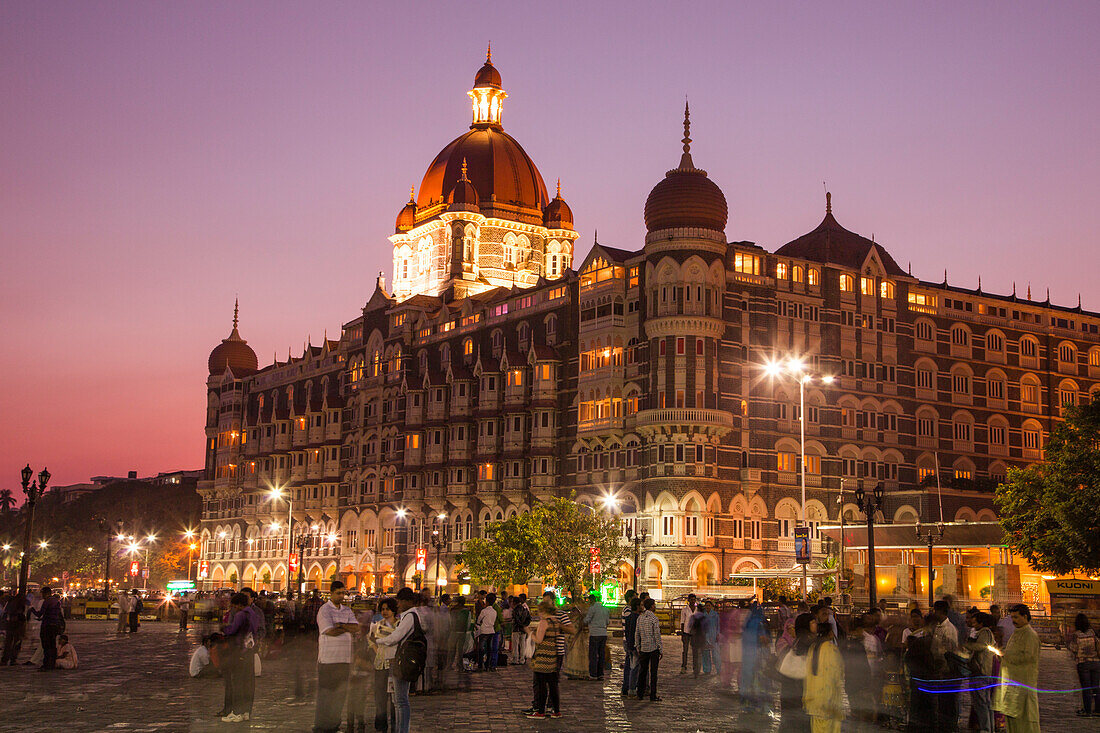 Menschen an der Wellington Pier vor The Taj Mahal Palace Hotel in der Abenddämmerung, Mumbai, Maharashtra, Indien