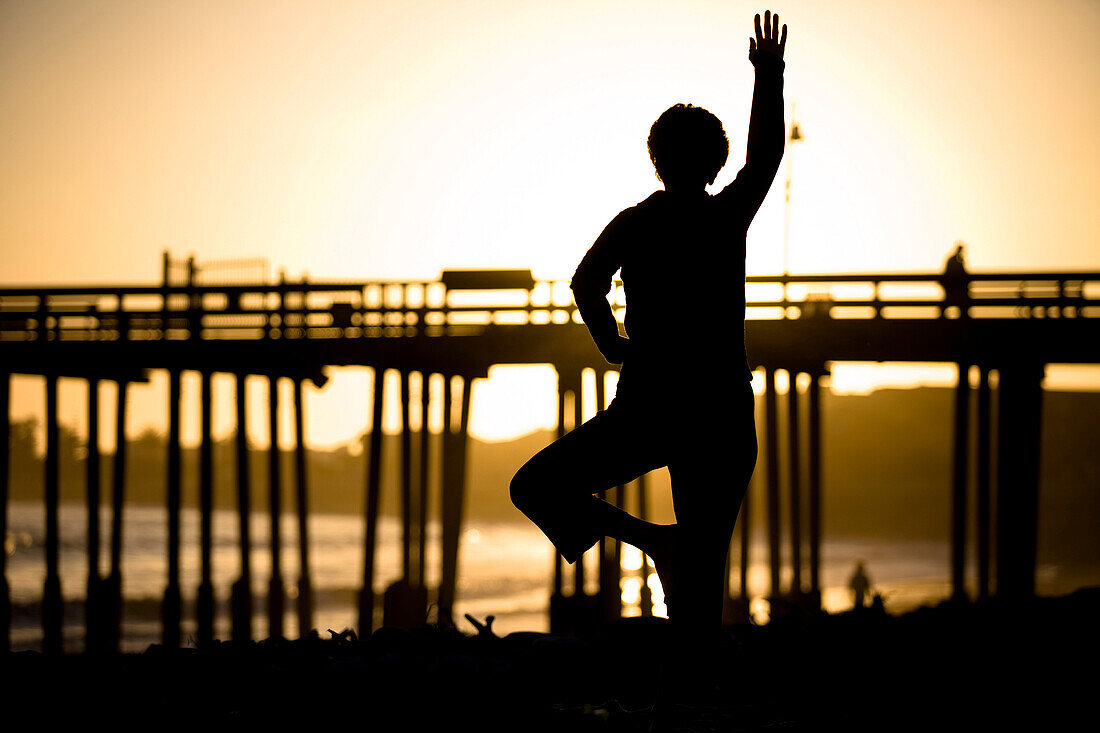 A silhouetted woman does yoga on the beach in Ventura, California Ventura, California, United States of America