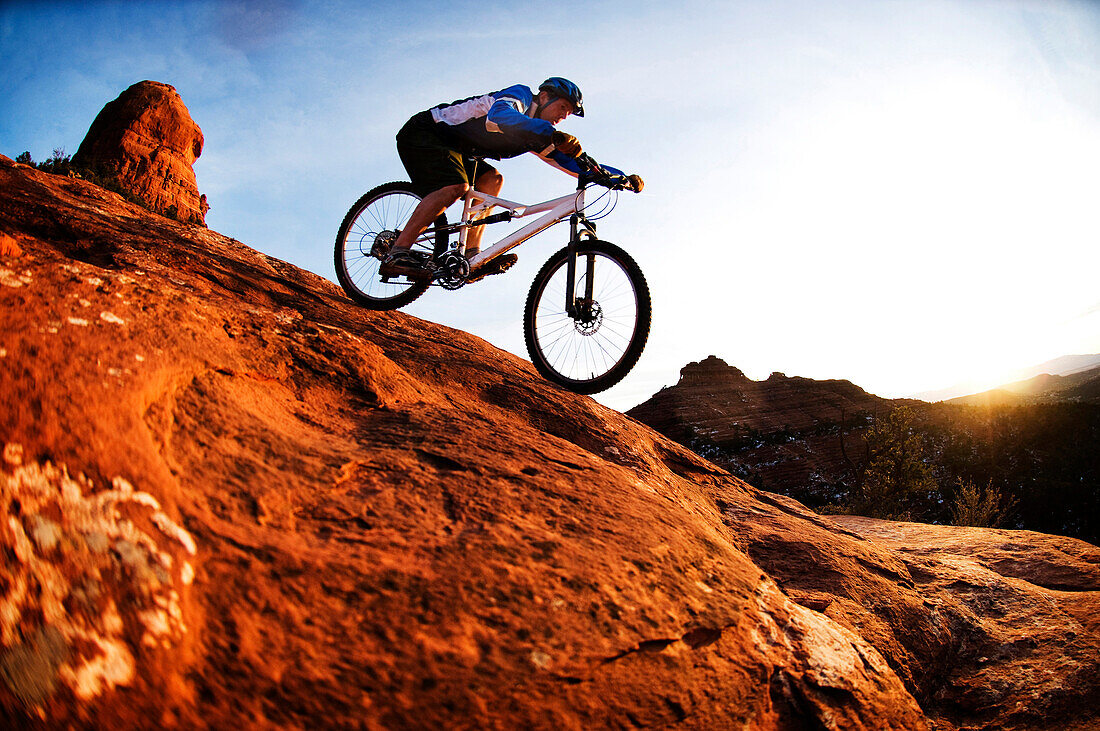 A middle age man rides his mountain bike through the red rock country around Sedona, Az at sunset Sedona, AZ, USA