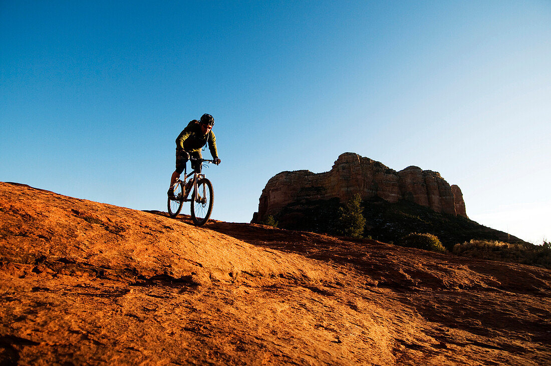 A middle age man rides his mountain bikes through the red rock country of Sedona, AZ Sedona, AZ, USA