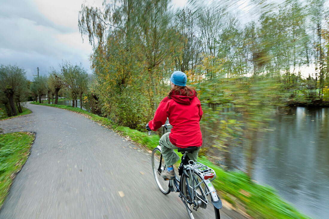 A woman cycles near Gouda, South Holland, Netherlands South Holland, The Netherlands