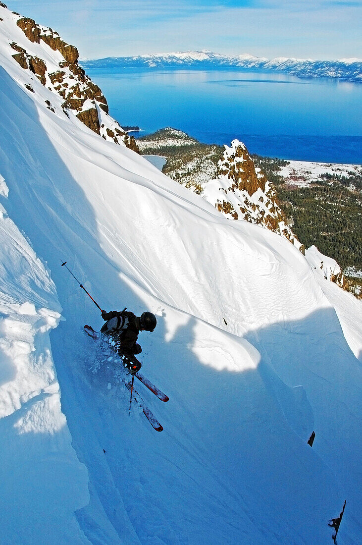 A skier descends The Cross on Mount Tallac with Lake Tahoe in the background Lake Tahoe, California, USA