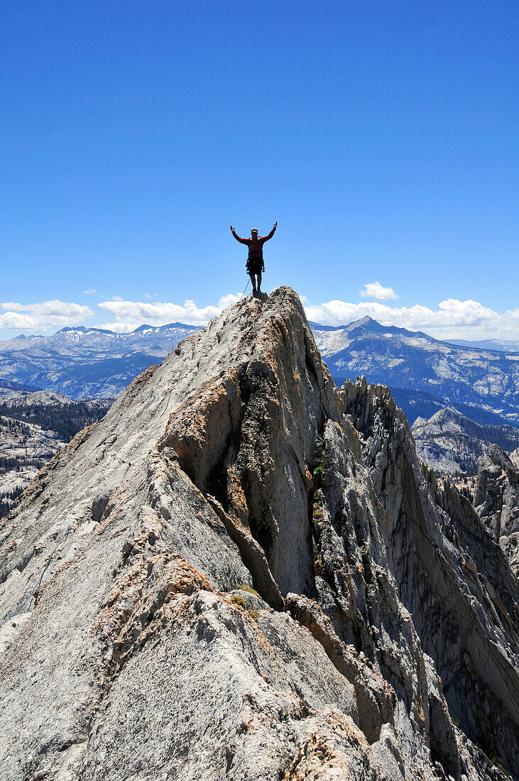 A rock climber stands with arms outstretched on Matthes Crest in Yosemite National Park, California Yosemite National Park, California, USA