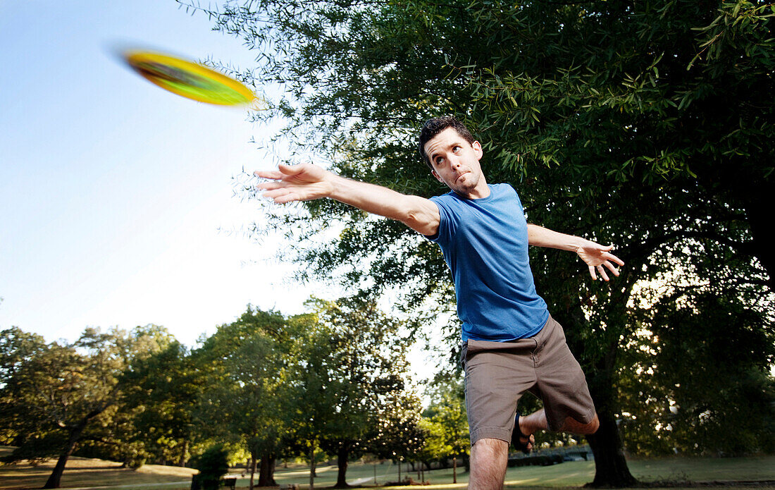 Closeup of a man making a backhanded drive playing disc golf. (Motion Blur), Birmingham, Alabama, United States