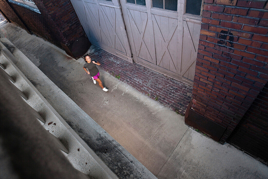 A teenage girl runs through an alleyway in downtown Birmingham, Alabama Birmingham, Alabama, United States