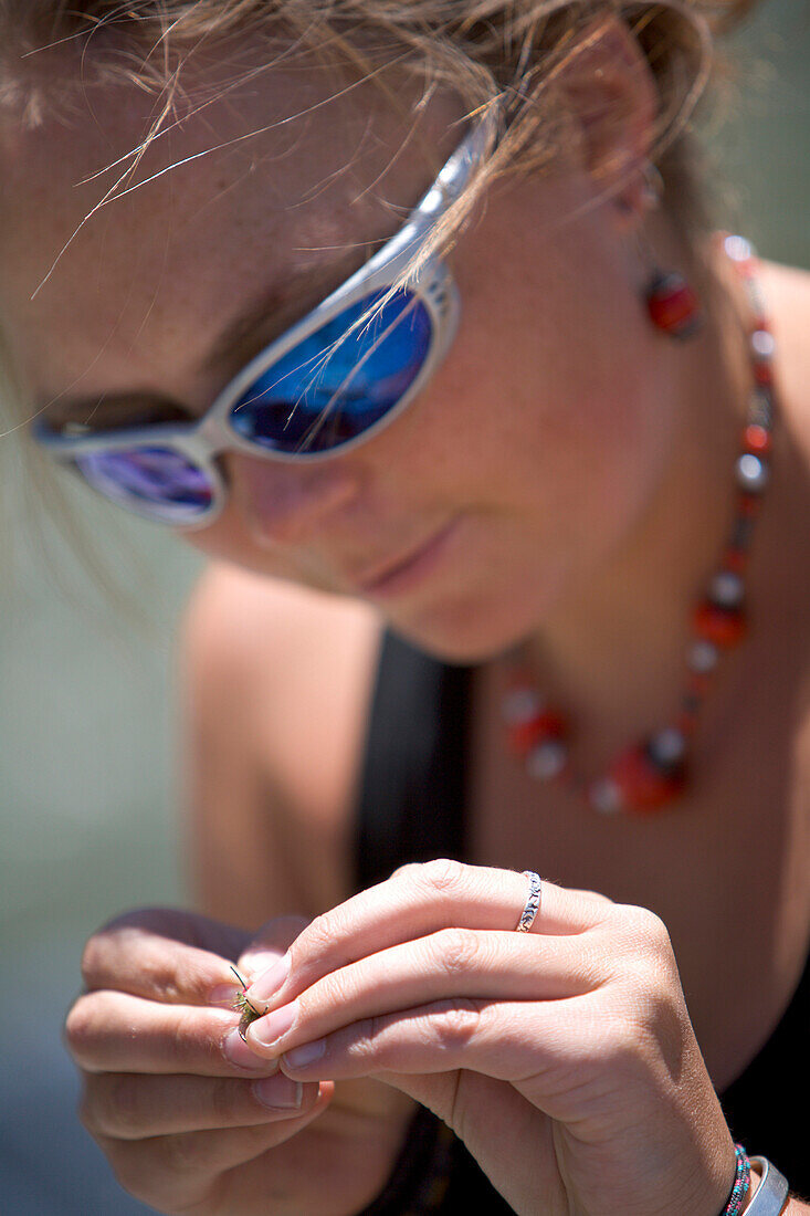 A close up of a female looking down and tying a fly to her line Jackson Hole, Wyoming, U.S.A.