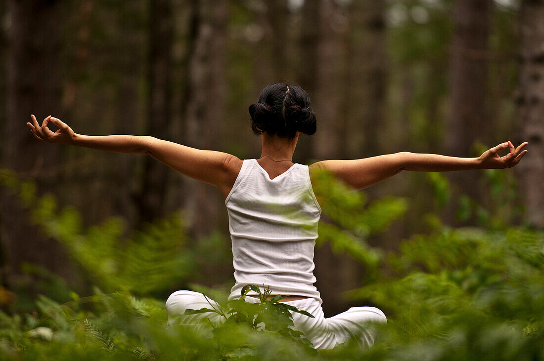 Woman doing yoga in a forest NOrth Cownay, NH, USA