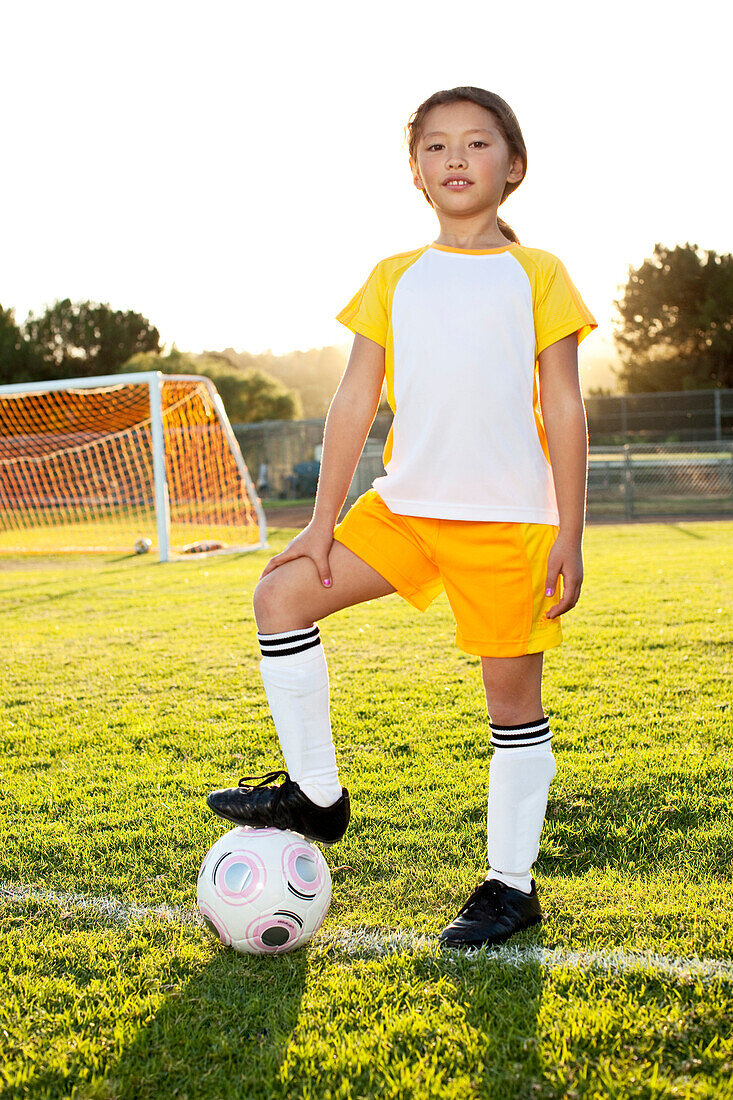 A young girl posing with her soccer ball on a soccer field in Los Angeles, California.++, Los Angeles, California, USA
