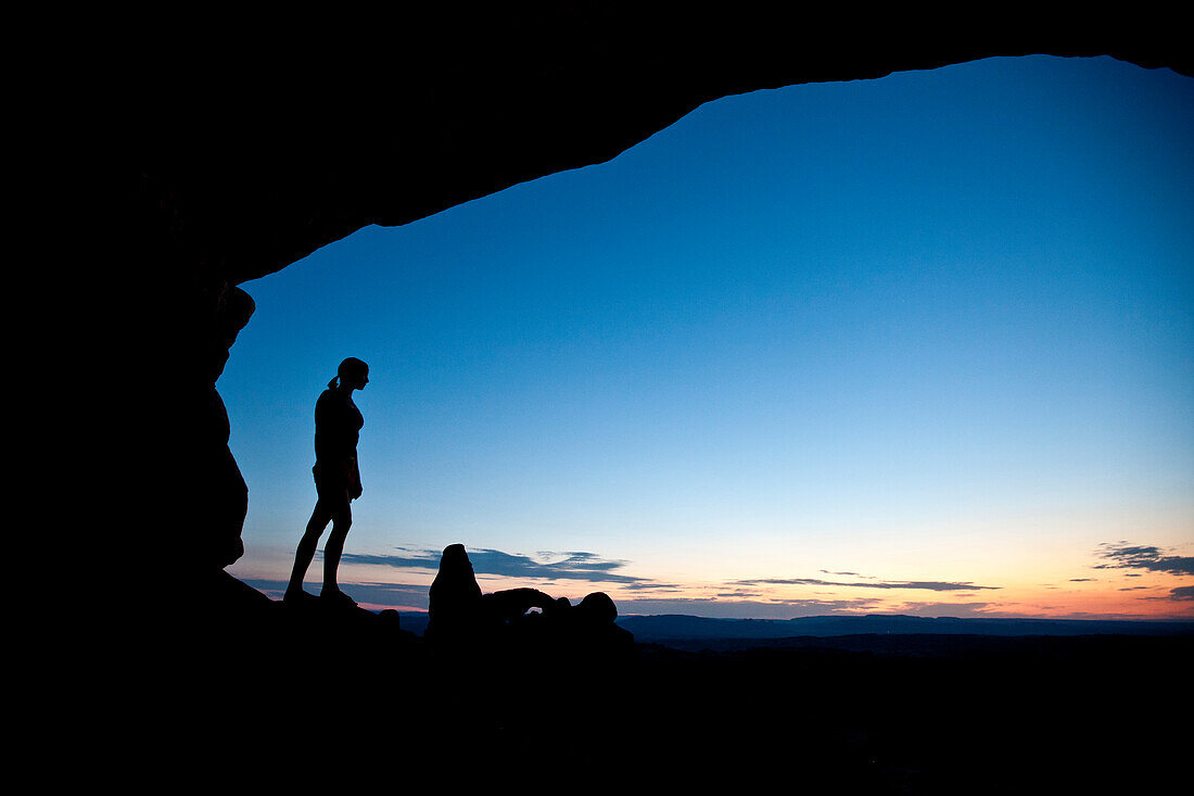 Female hiker overlooks the Turret Arch at sunset in Arches National Park near Moab Utah Moab, Utah, USA