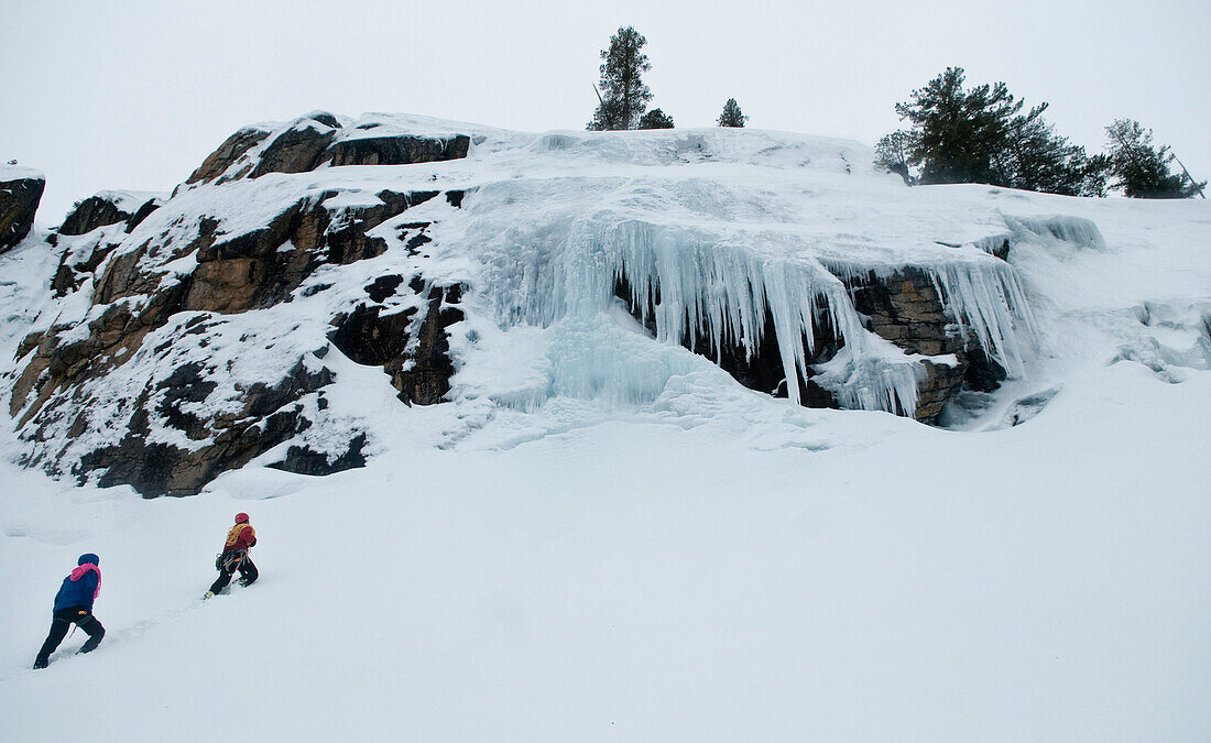 Two men hike up to the base of the ice climb in Truckee, California Truckee, California, USA