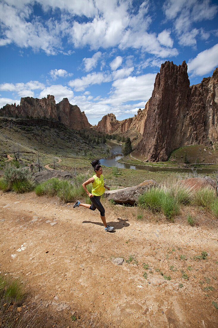 Female trail running with river in distance Bend, Oregon, United States