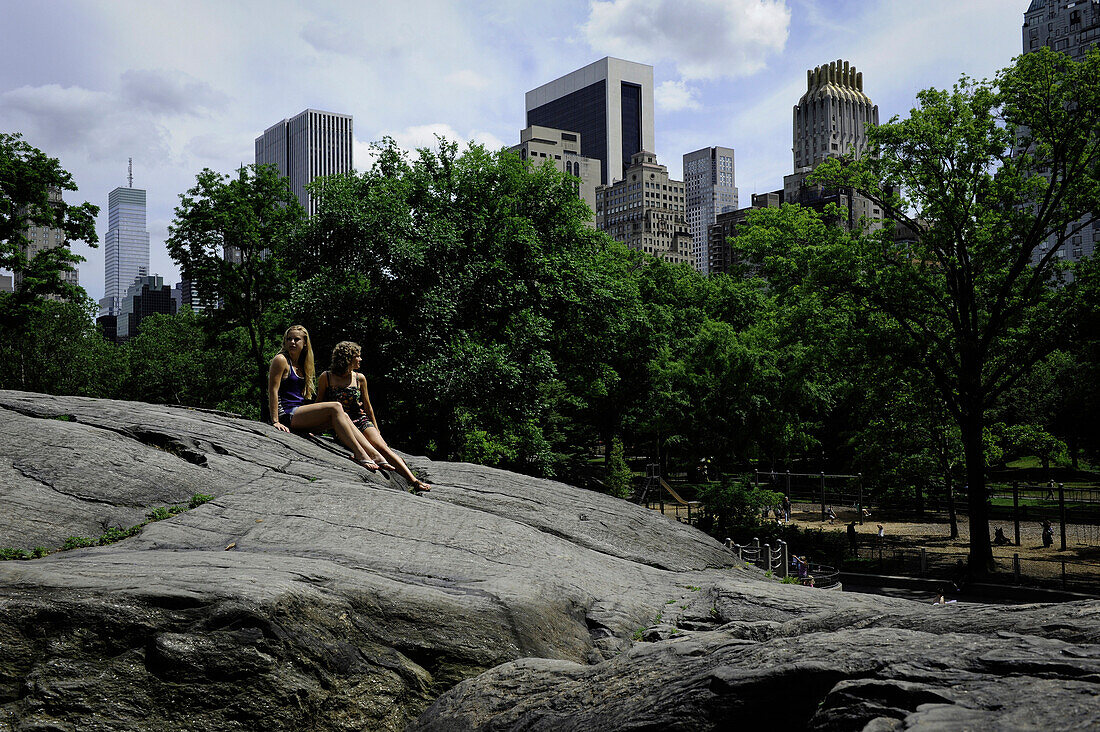 Two girls rest on a rock in New York City New York City, New York, USA