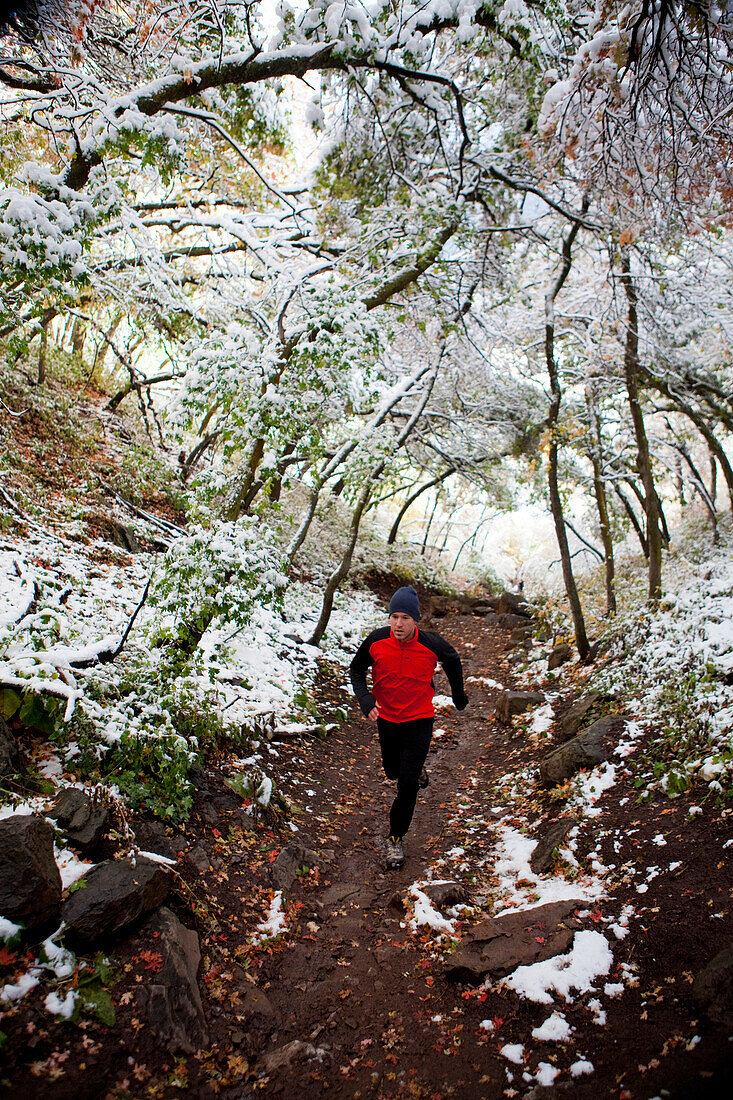 A man out for a run on the pipeline trail after the first snowfall of the season Utah, USA