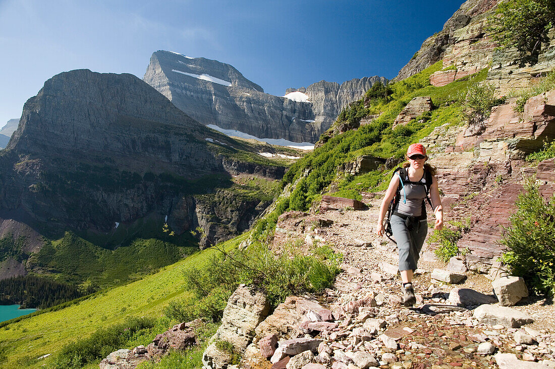 A woman in her early thirties hikes along the Grinnell Glacier trail in Glacier National Park, Montana Glacier National Park, Montana, United States of America