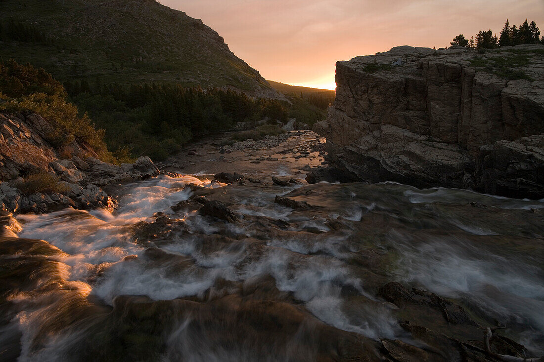 Sunrise on a river flowing from Lake McDonald in Glacier National Park in the Rocky Mountains Glacier National Park, Montana, United States of America