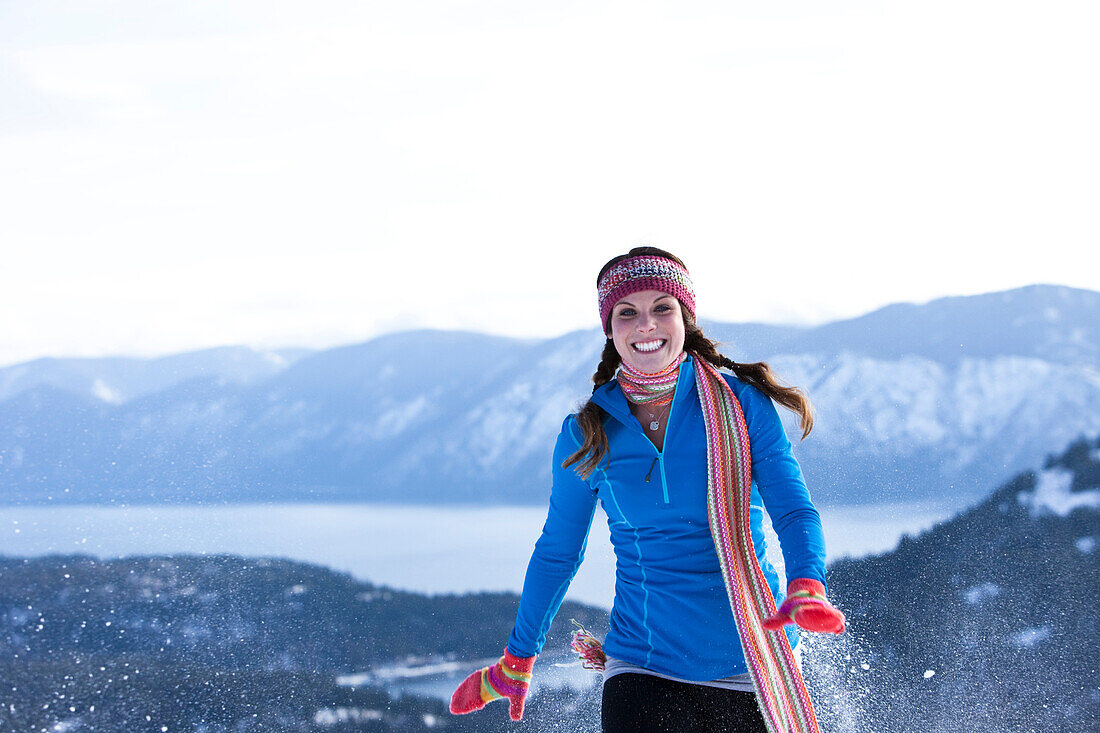 A athletic young woman laughs while snowshoeing in Idaho., Sandpoint, Idaho, USA