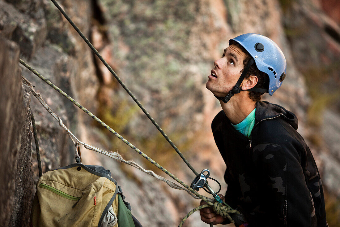 A athletic man rock climbing belays his partner in Montana., Bozeman, Montana, USA