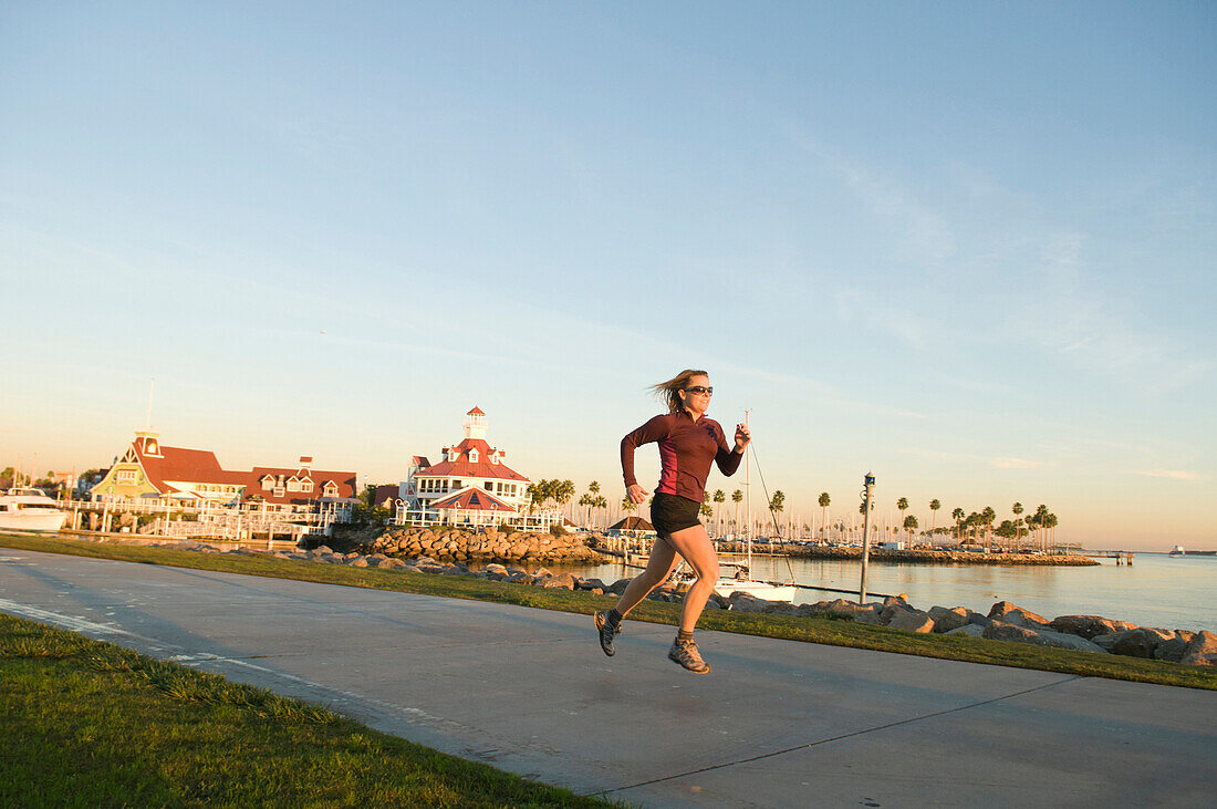 A woman running along the Long Beach Boardwalk, Long Beach, California., Long Beach, California, usa