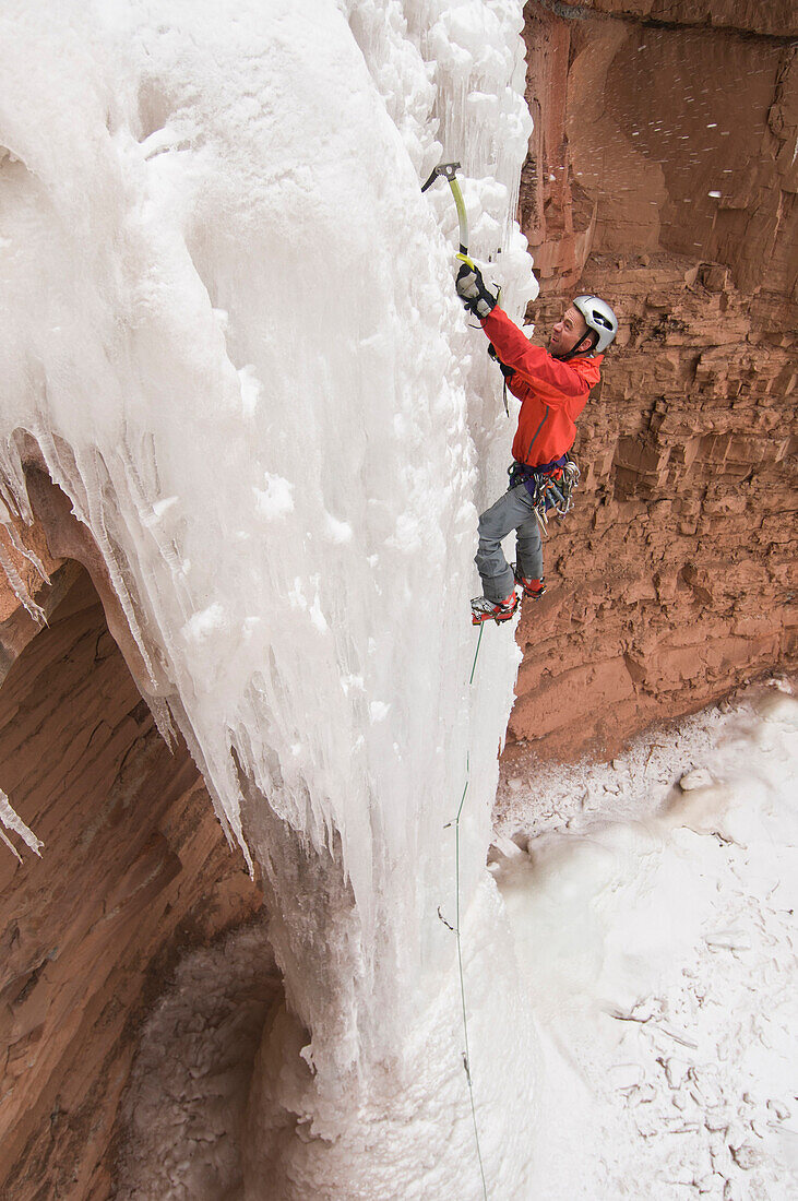Mid adult male ice  climbing an ice pillar, San Juan National Forest, Durango, Colorado., Durango, Colorado, usa